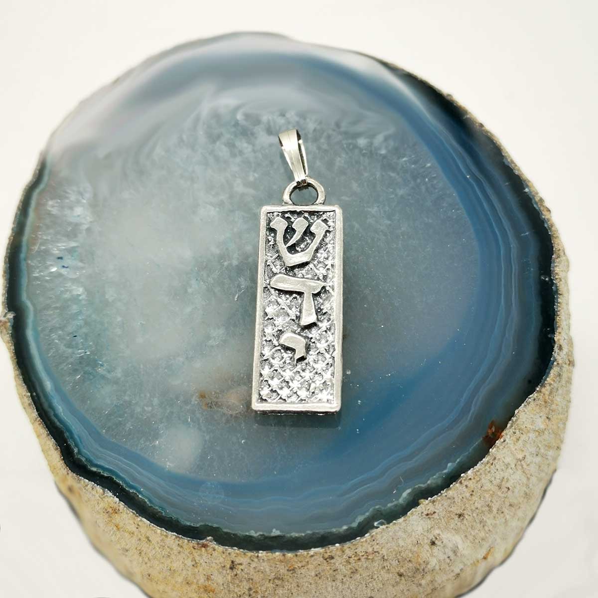 Le nom divin Shaddai, signifiant D.ieu Tout-Puissant, est gravé en hébreu sur ce délicat pendentif.