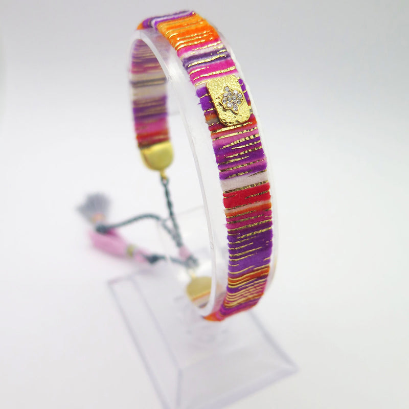 C'est un tout nouveau bracelet qui voit le jour dans notre collection. Ce Bracelet de Soie et Ponpons tendance Orange et Violet, tout doux à porter ravira celle qui le portera.